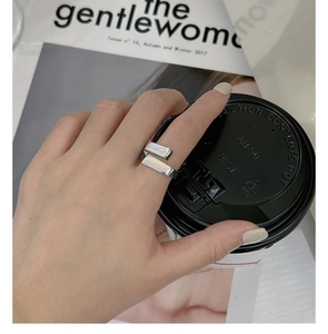 Minimalist S925 sterling silver ring with rectangular ends worn by a hand with coffee cup