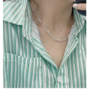 Gros plan d'un collier en argent sterling S925 à billes porté sur une chemise