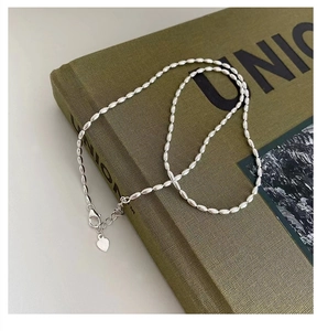 Detail of 925 sterling silver rice bead necklace with lobster clasp and heart charm