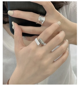 Detail of silver S925 rings featuring geometric block and wavy engraved metal bands