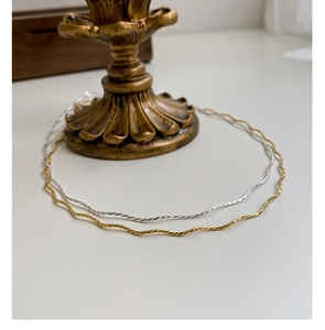 Detailed view of minimalist S925 sterling silver wavy necklaces in gold and silver finish