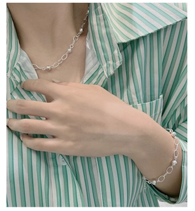 Gros plan d'un collier et d'un bracelet en argent S925 avec perles polies sur un mannequin