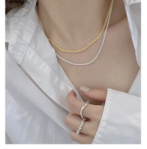 Close-up of S925 sterling silver twist rope chain necklaces and minimalist rings on model