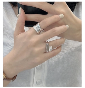 Close-up of S925 sterling silver geometric square rings on hand with mirror reflection