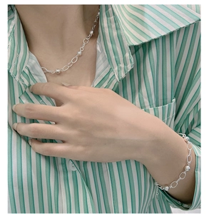 Close-up of a 925 sterling silver bead bracelet and matching necklace on a female model