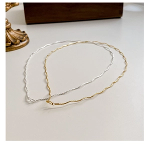 Close-up of S925 sterling silver wavy chain necklaces in gold and silver finishes