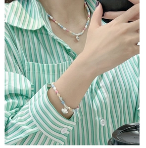 Macro shot of macaron colored beaded necklace and bracelet set with silver heart pendant