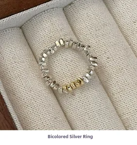 Vue macro d'une bague en argent 925 avec pépites irrégulières et finition bicolore or et argent