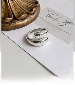 Macro shot of S925 sterling silver drop-shaped open ring on a vintage aesthetic background