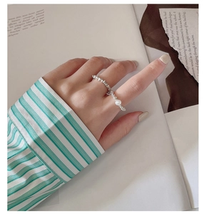Dettaglio dell'anello in argento S925 con perla bianca sulla mano di una modella
