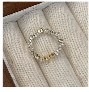 Détail d'une bague en argent 925 avec des pépites géométriques argentées et dorées