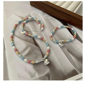 Detail showing S925 sterling silver heart charms on colorful bead necklace and bracelet set