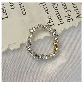 Gros plan de perles irrégulières en argent 925 et or sur une bague géométrique