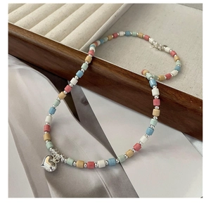 Detail of macaron colored beads necklace with polished silver heart pendant
