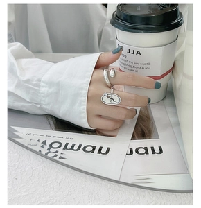 Chic silver ring set on hand featuring a textured signet ring and a wrap band