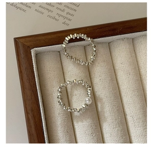 Dettaglio di anelli in perle d'argento S925 con perla d'acqua dolce su vassoio in velluto