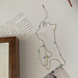 Minimalist S925 sterling silver beaded necklace with colorful round accents on magazine