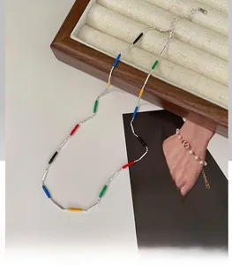 Detail of colorful rainbow beaded necklace with silver chain on fashion magazine background