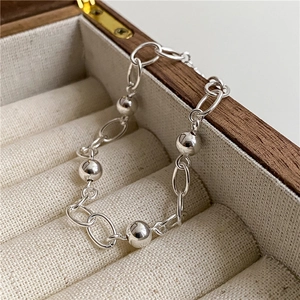 Minimalist 925 sterling silver bead chain bracelet on a wooden jewelry display case