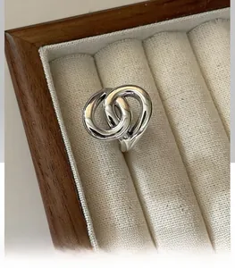 Close-up of interlocking S925 sterling silver rings in a luxury jewelry box display