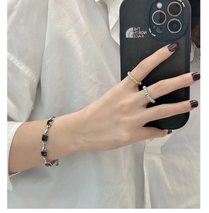 Detail of vintage S925 silver beaded rings and geometric black square charm bracelet