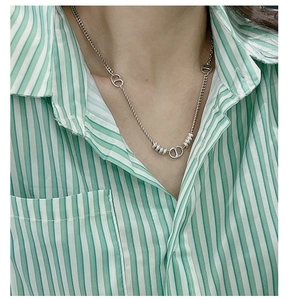 Détail du collier torsadé en argent 925 avec motif CD vintage porté par un mannequin