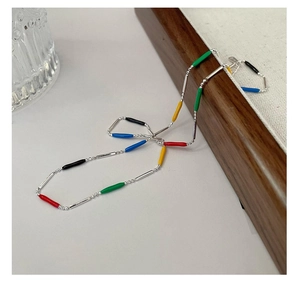 Detail of S925 silver necklace featuring colorful enamel beads on a wooden tray