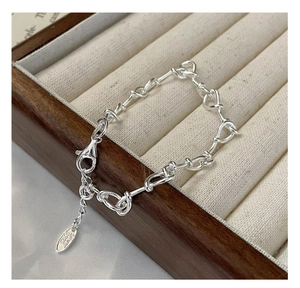 Macro view of a 925 sterling silver twisted knot chain bracelet with lobster clasp detail