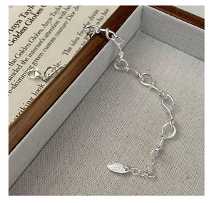 Detailed macro view of S925 sterling silver knotted chain bracelet with lobster clasp