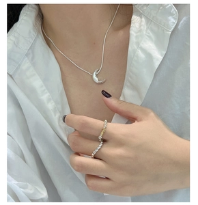 Detail von minimalistischer S925 Silber Mondkette und gedrehtem Seilring an einem Model