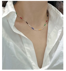 Detail of S925 silver rainbow necklace with colorful enamel tubes on a beaded chain