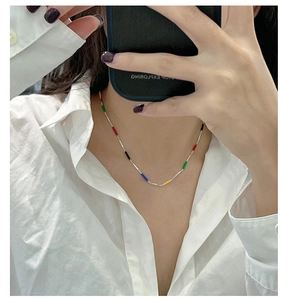 Mirror selfie showing a silver rainbow pendant necklace with colorful enamel beads