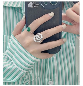 Macro view of S925 silver knotted ring and green stone signet ring set