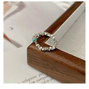 Detailed view of S925 silver beaded ring with turquoise and marble stones on vintage paper