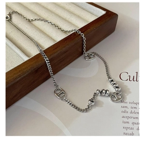 Détail de la chaîne en argent sterling S925 avec maillon CD sur un plateau en bois