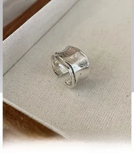 Macro shot of silver wave ring with unique liquid metal folded texture and open band