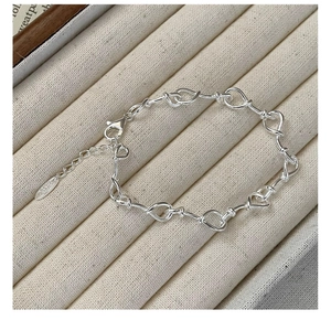 Detail of 925 sterling silver heart-link bracelet with S925 hallmark tag and lobster clasp