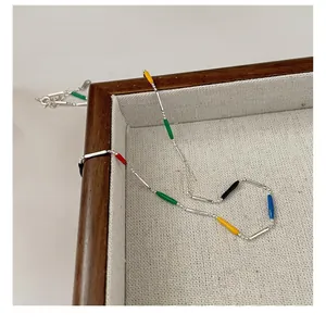 Macro shot of S925 sterling silver rainbow enamel necklace on a wooden jewelry tray