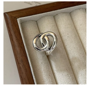 Macro view of S925 sterling silver overlapping rings in a wooden jewelry box