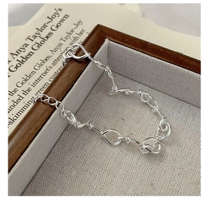 Detail of twisted knot link 925 sterling silver bracelet on high-end fashion jewelry tray