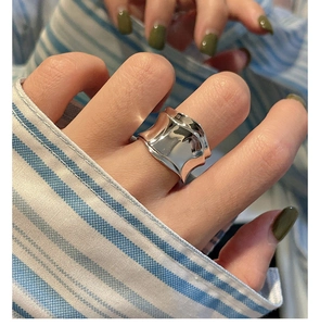 Close-up of a wide wavy S925 sterling silver ring with a liquid metal mirror finish