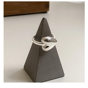 Close-up of a polished S925 sterling silver heart ring on a conical display stand