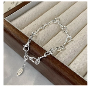 Close-up of S925 sterling silver knot bracelet with lobster clasp in a jewelry box