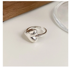 Macro shot of silver heart ring with mirror polished finish and adjustable open design