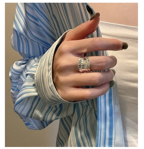 Macro detail of silver wavy textured wide band ring on model in casual styling