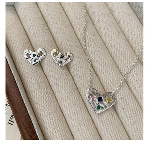 Détail de la parure de bijoux cœur en argent S925 avec gemmes colorées et texture martelée