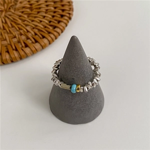 Handmade S925 silver beaded elastic ring with turquoise accent on a jewelry display stand