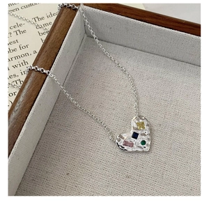 Détail du collier cœur en argent S925 avec texture martelée et pierres précieuses