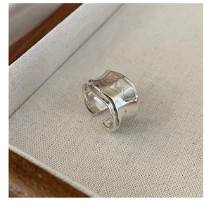 Macro detail of S925 sterling silver wide ring with irregular wavy lava texture design