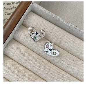 Gros plan sur boucles d'oreilles cœur en argent avec texture martelée et pierres colorées